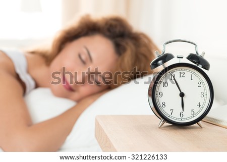 Beautiful happy woman sleeping in her bedroom in the morning. Well being and healthy sleeping concept.