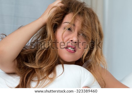 Young tousled woman waking up early in the morning