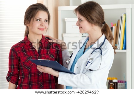 Friendly female doctor touching patient shoulder for encouragement, empathy, cheering and support while medical examination. Trust and ethics concept. Good news, healthcare and medical concept