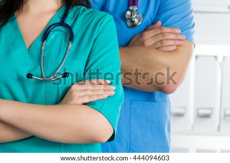 Close up view of two doctors standing with their arms crossed on chest ready to work. Health care, medical and teamwork concept.