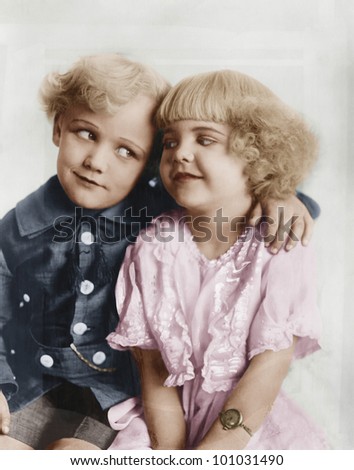Portrait of a boy and girl with arm around her