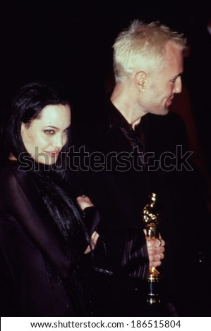 Angelina Jolie and her brother Jamie Voight with her Academy Award at the Vanity Fair post-award party, 3/26/00