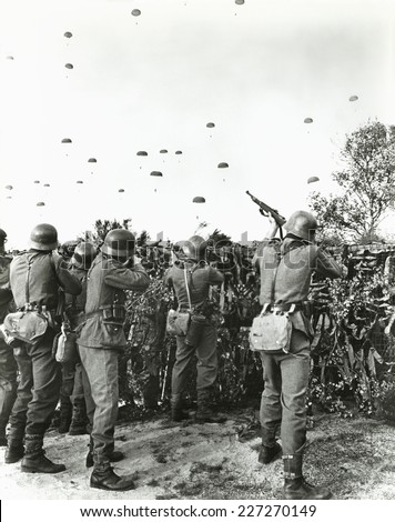 German soldiers shooting at enemy parachuting into field