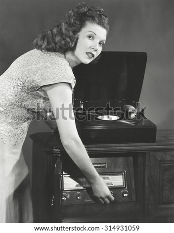Woman playing record album on phonograph