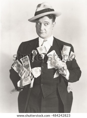 Man holding wads of fake money