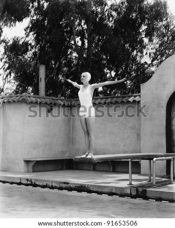Woman on diving board at swimming pool
