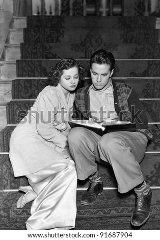 Couple reading together on stairs