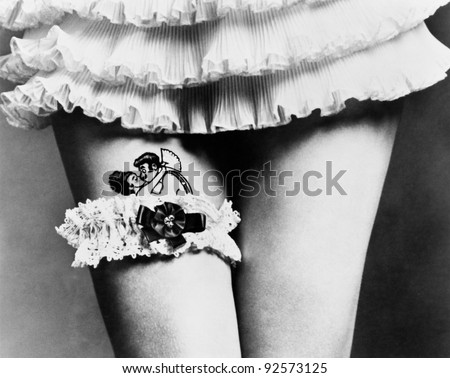 View of a woman hiding a tattoo with a garter on her thighs