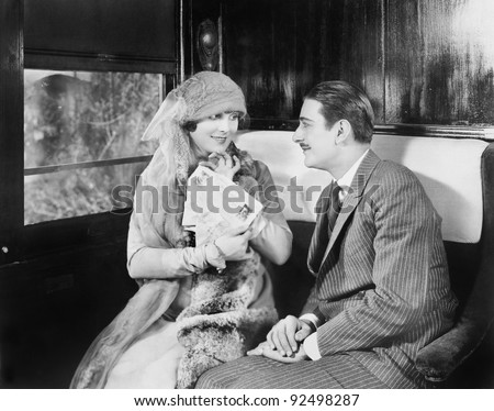 Couple in a compartment of a train looking and talking with each other