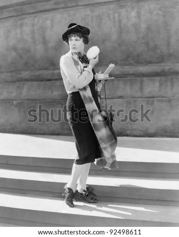 Young woman on steps, holding a powder puff