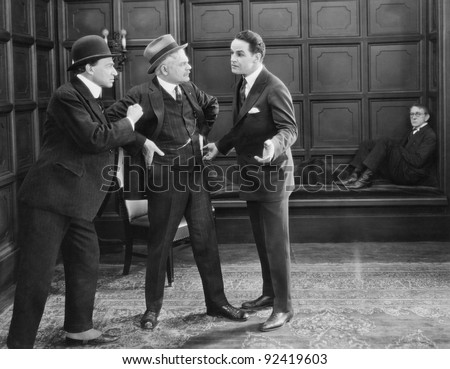 Three men standing together arguing