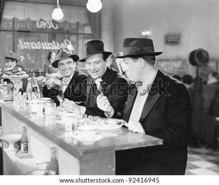 Three men sitting at the counter of a diner