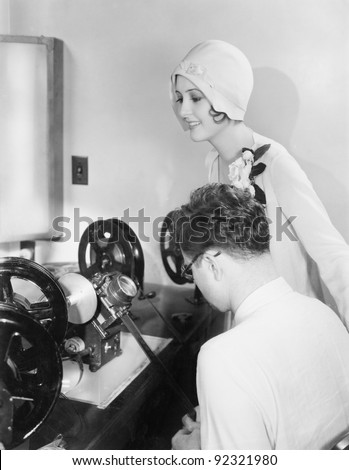 Woman at an editing machine with an editor reviewing film