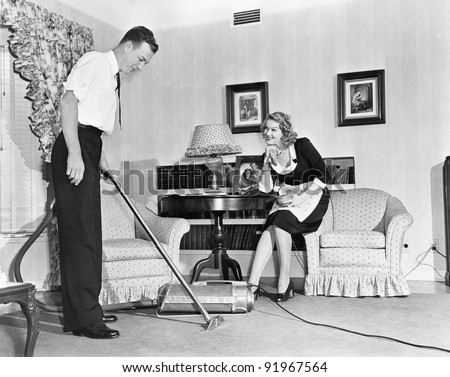 Salesperson demonstrates a vacuum cleaner to a housewife  in her home
