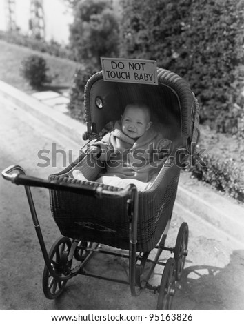 Baby with sign saying do not touch baby
