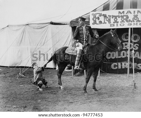 Circus performer pulling horses tail