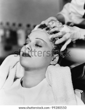 Hairdresser cleaning hair of a young woman in a hair salon