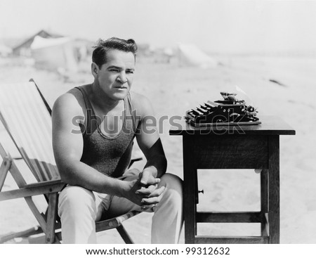 Man sitting at the beach with his typewriter