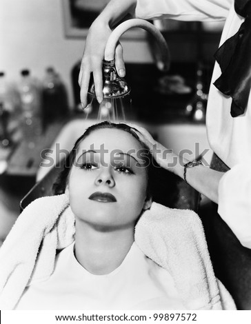 View of a female hairdresser washing hair of a young woman in a hair salon