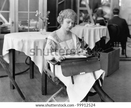 Young woman sitting on a chair and reading documents