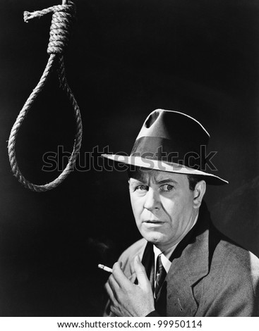 If smoking doesn\'t kill you ... Man in hat and cigarette standing next to a noose