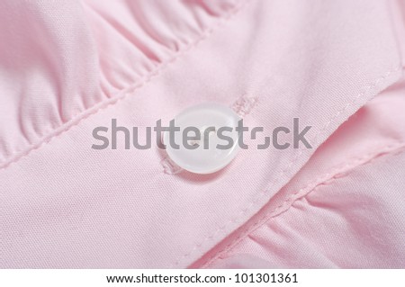 White button of a pink shirt