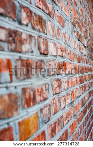 blurred brick wall of red brick appearance at an acute angle