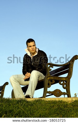 Young man sitting on the metal bench