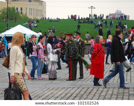 MOSCOW, RUSSIA -  MAY 09: War veterans talking to young ladies in the park. Victory Day celebration on Poklonnaya Hill (Moscow) on May 09, 2012 in Moscow, Russia.