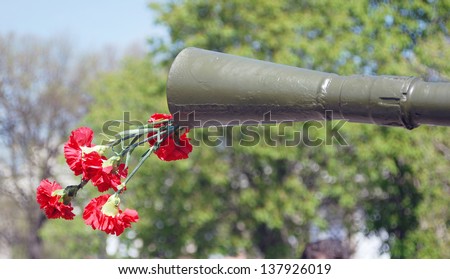 MOSCOW, RUSSIA - MAY 09: Red carnation flowers sticking out of the barrel of a machine gun. Holiday decoration in the Gorky park. Victory Day celebration on May 09, 2013 in Moscow, Russia.