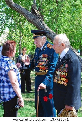 MOSCOW, RUSSIA - MAY 09: War veterans speak to a woman. Victory Day celebration in the Gorky park on May 09, 2013 in Moscow.