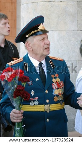MOSCOW, RUSSIA - MAY 09: A war veteran holds flowers. Victory Day celebration in the Gorky park on May 09, 2013 in Moscow.