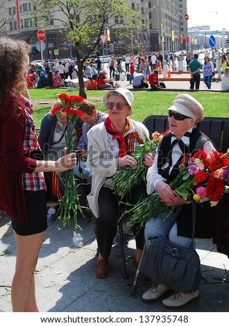 MOSCOW, RUSSIA - MAY 09: War veterans receive flowers from a lady. Victory Day celebration on May 09, 2013 in Moscow.