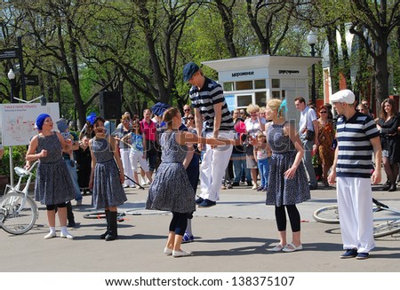 MOSCOW, RUSSIA - MAY 09: Young people jumping. Actors perform in the Gorky park. Victory Day celebration on May 09, 2013 in Moscow.