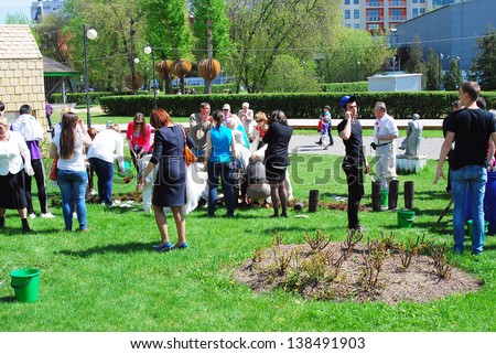 MOSCOW, RUSSIA - MAY 09: Young and senior people plant roses in the Muzeon park in Moscow. It\'s a part of Victory Day celebration on May 09, 2013 in Moscow.