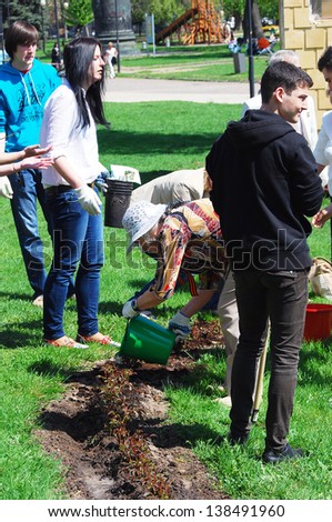 MOSCOW, RUSSIA - MAY 09: Young and senior people plant roses in the Muzeon park in Moscow. It\'s a part of Victory Day celebration on May 09, 2013 in Moscow.
