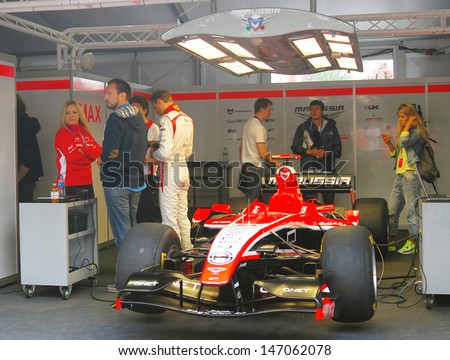 MOSCOW - JULY 20: Marussia F1 sport car at Moscow City Racing, a man in white sports suit is Max Chilton. Formula 1 teams show in historical city center of Moscow on July 20, 2013 in Moscow, Russia.
