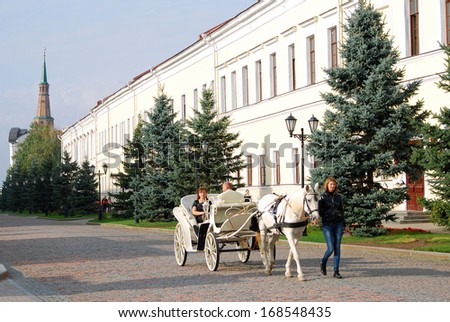 KAZAN, RUSSIA - SEPTEMBER 13: A carriage pulled by a white horse. Kremlin in Kazan, popular touristic landmark, UNESCO World Heritage Site. Taken on September 13, 2012 in Kazan, Russia.