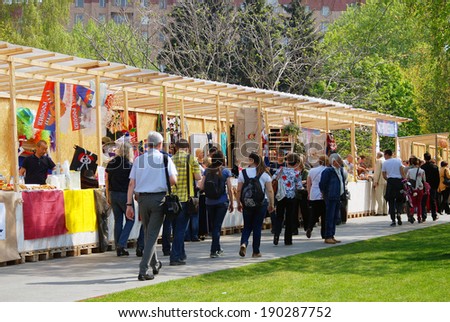 MOSCOW - MAY 01, 2014: Souvenir sellers in Muzeon park in Moscow. People purchase souverins or pass by. Spring and Labor Day celebration in Moscow.