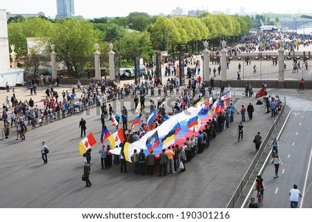 MOSCOW - MAY 01, 2014: People hold a Russian flag on the Moscow river embankment, in Gorky park. Spring and Labor Day (May Day) celebration.