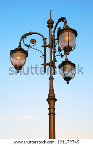 Vintage street light, blue sky background.
