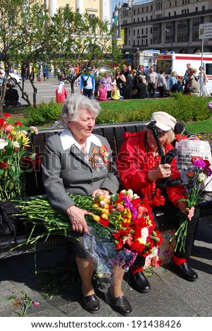 MOSCOW, RUSSIA - MAY 09: Portrait of two senior women,  war veterans holding flowers. Victory Day celebration on May 09, 2013 in Moscow.