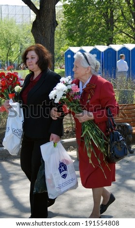 MOSCOW, RUSSIA - MAY 09: A war veteran holding flowers. Victory Day celebration in the Gorky park on May 09, 2013 in Moscow.