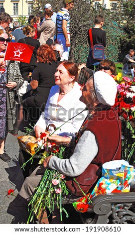 MOSCOW - MAY 09, 2014:  A war veteran woman receives flowers. Victory Day celebration in Moscow.