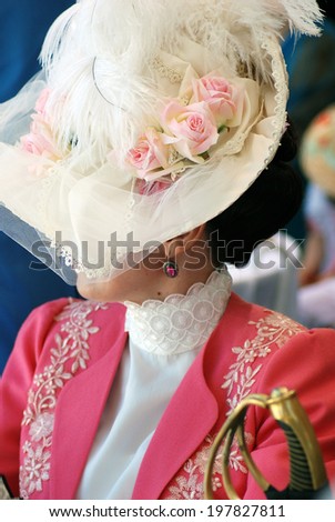 MOSCOW - JUNE 08, 2014: Portrait of a woman in historical costume. Her hat is decorated by pink roses. Times and Ages International Historical Festival in Kolomenskoye park, Moscow.