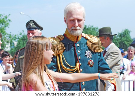 MOSCOW - JUNE 08, 2014: Portrait of man and woman in historical costumes. They sit in a carriage, a woman holds umbrella. Times and Ages International Historical Festival in Kolomenskoye park, Moscow.