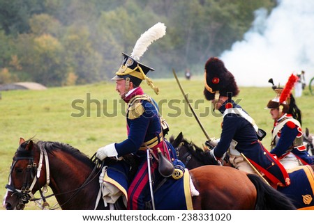 MOSCOW REGION - SEPTEMBER 07, 2014: Reenactors dressed as Napoleonic war soldiers ride horses at Borodino battle historical reenactment.