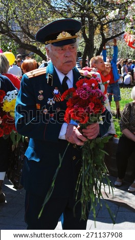 MOSCOW - MAY 09, 2014: Portrait of a war veteran holding flowers. Victory Day celebration in Moscow.