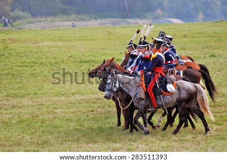 MOSCOW REGION - SEPTEMBER 07, 2014: Reenactors dressed as Napoleonic war soldiers ride horses at Borodino battle historical reenactment.