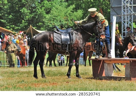MOSCOW - JUNE 08, 2014: Horse riders competition. A rider is dressed in vintage military uniform. Times and Ages International Historical Festival in Kolomenskoye, Moscow.